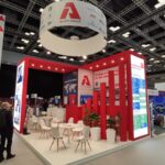 Stand Allied Group all'IBF/25 ITER Business Forum, Marsiglia. Design rosso e bianco, tavoli e sedie.